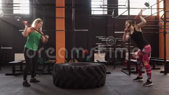 健身妇女一起在健身房做大锤式秋千锻炼视频的预览图