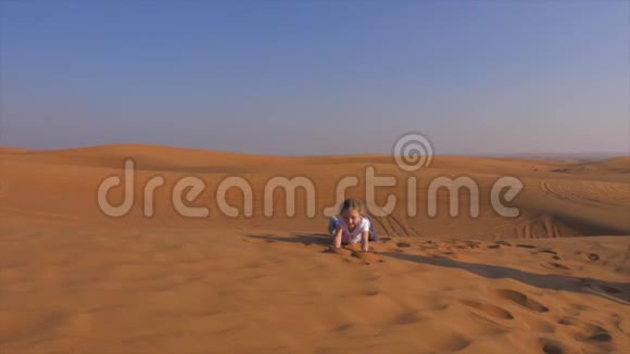小女孩在沙漠里玩沙子表演杂技表演视频的预览图