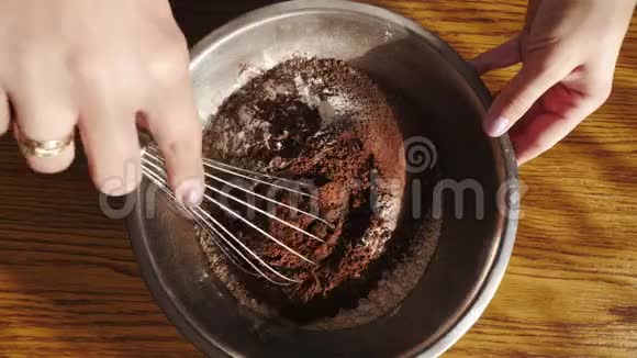 烹饪蛋糕女人把面粉和可可粉混合在碗里上景视频的预览图