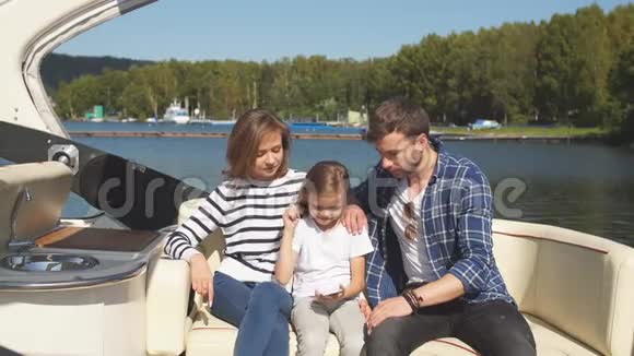 家人和女儿一起在湖边的帆船上度假视频的预览图