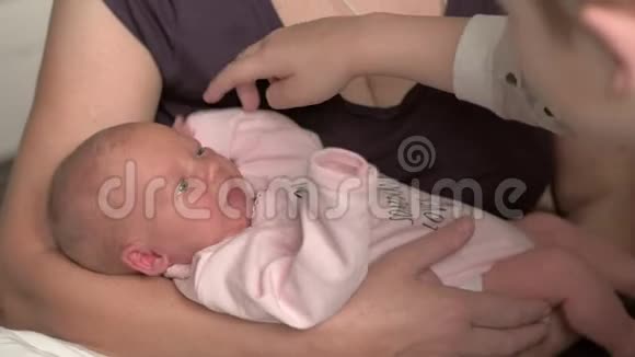 奶奶带着新生儿和弟弟抚摸婴儿的手视频的预览图