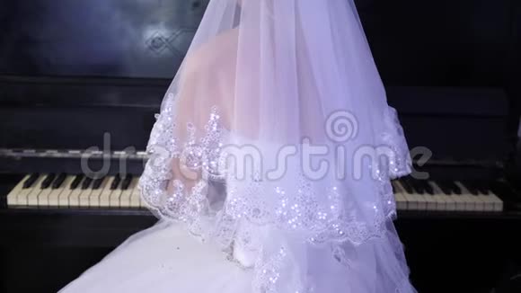 穿白色连衣裙的女孩弹钢琴新娘在钢琴上演奏一首音乐音乐生意视频的预览图