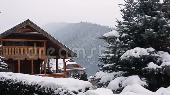 冬天下雪的时候山上的圣诞木大厦松林附近滑雪场的舒适小屋小屋视频的预览图
