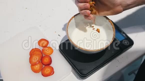 碗里的白色酸奶把麦片洒在酸奶上视频的预览图