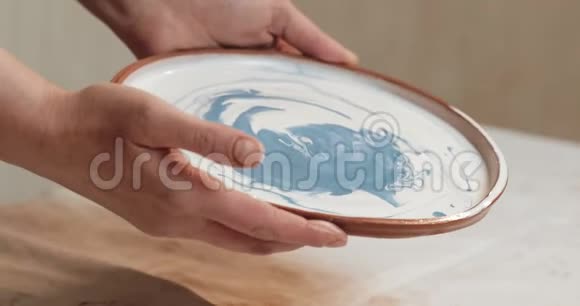 熟练的陶工釉从红泥中覆盖盘子关上门进程陶瓷车间视频的预览图