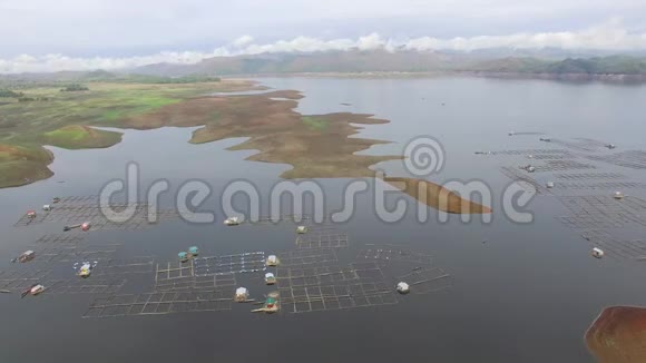 水电大坝水库在多山的科迪勒拉形成了巨大的湖泊在那里水产养殖蓬勃发展视频的预览图