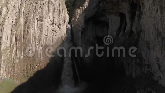 从高加索陡峭的悬崖上俯瞰巨大的瀑布近距离拍摄了一条大溪流视频的预览图
