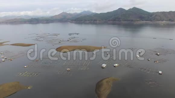 水电大坝水库在多山的科迪勒拉形成了巨大的湖泊在那里水产养殖蓬勃发展视频的预览图