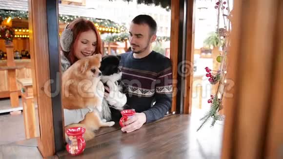 有几个情人和一只可爱的狗拥抱在一起他们相处得很好穿着衣服的沃德后面的圣诞灯视频的预览图