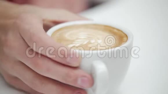 顾客从咖啡师手中端起一杯咖啡咖啡配拿铁艺术视频的预览图