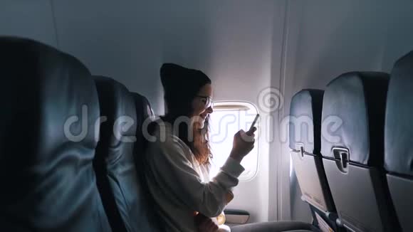 女孩在飞行中使用智能手机视频的预览图