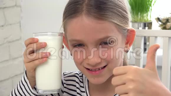 儿童在厨房早餐时喝牛奶女孩品尝奶制品视频的预览图