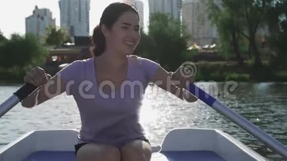 美丽的女孩笑着在湖上划船视频的预览图