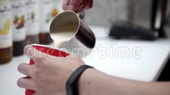 咖啡师从一个水罐倒出一杯咖啡到一个纸杯视频的预览图