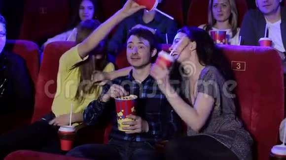 一群朋友在电影院看电影朋友们在电影院扔爆米花视频的预览图