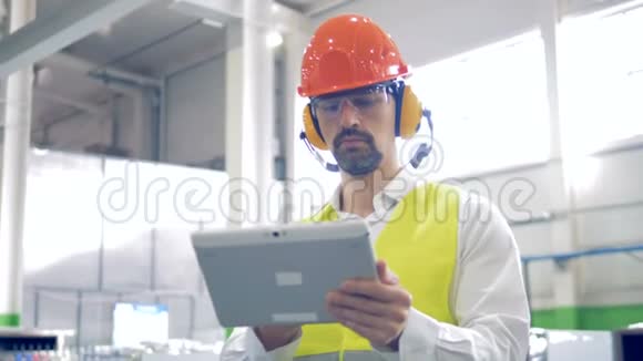 一个人在一家工业工厂的平板电脑上工作关门视频的预览图