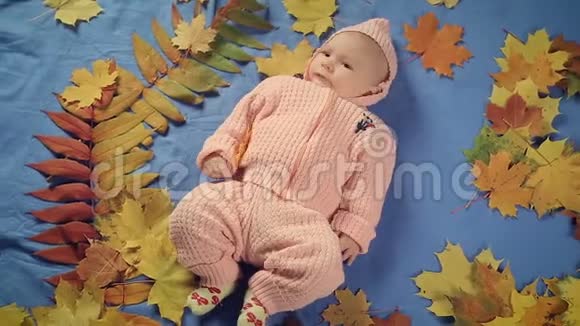 躺在地毯和秋叶上的新生女婴视频的预览图