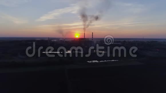 排放到空气中无人驾驶飞机在背景日落和城市中看到浓烟的工厂管道视频的预览图