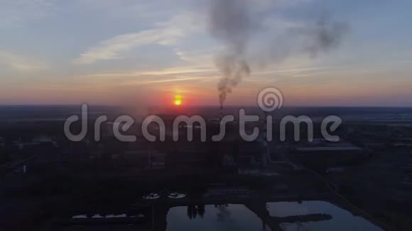 工业工厂日落背景下的吸烟管道和城市的空气污染视频的预览图