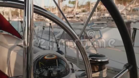 背景上带有模糊游艇的罗盘和游艇方向盘的聚焦视图视频的预览图