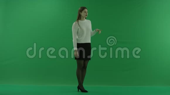 年轻女子站在半个转弯处看着屏幕滚动屏幕思考绿色屏幕上的东西视频的预览图