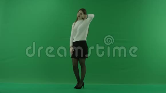 女孩站在一个半转弯的地方看着左边向绿色屏幕上的摄像机伸出大拇指视频的预览图