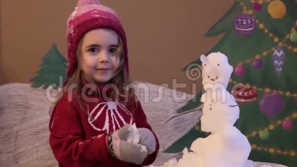 女孩在冬天雕刻雪人冬天可爱小女孩的情感肖像彩绘圣诞背景视频的预览图