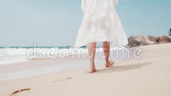 在阳光明媚的日子里一个年轻的女人在海边散步视频的预览图