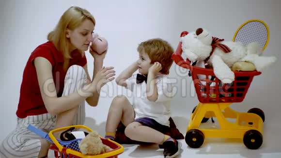母子俩玩购物妈妈教儿子数钱微笑的小男孩和妈妈一起玩商店视频的预览图