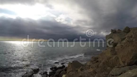 海浪拍打着海岸的石头云彩飞向太阳视频的预览图