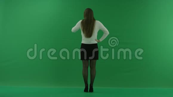 女孩站在镜头前手臂在她的腰上她在绿屏上等着什么视频的预览图