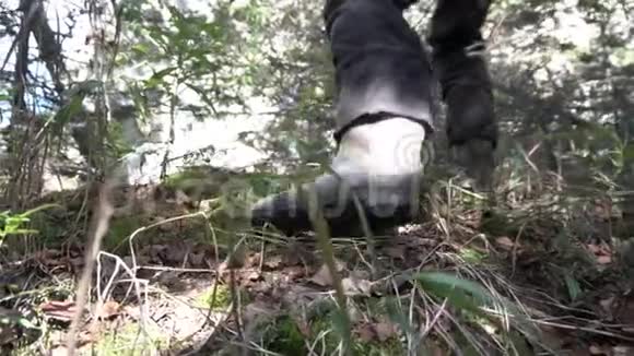 在一条山路上近距离练习登山鞋录像接近男人的靴子和腿爬上岩石视频的预览图