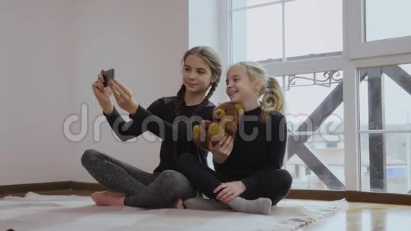 两个小女孩用玩具熊做自拍视频的预览图