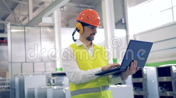 一个戴着安全帽的人在一家工业工厂工作视频的预览图