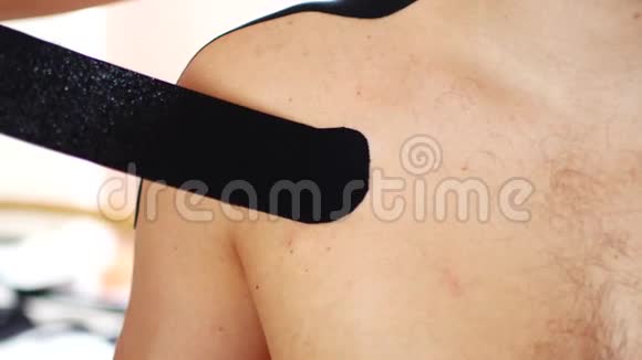 运动员肩伤后应加以预防医生正在用动能绷带男子的肩膀上打字视频的预览图