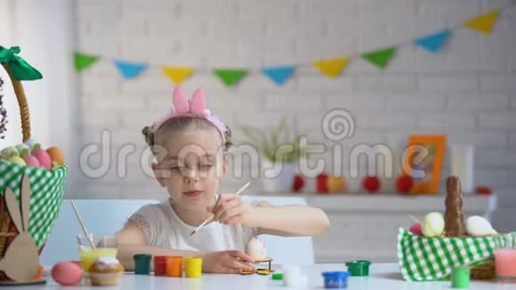 可爱的小女孩用五颜六色的颜料装饰复活节彩蛋才华横溢的孩子视频的预览图