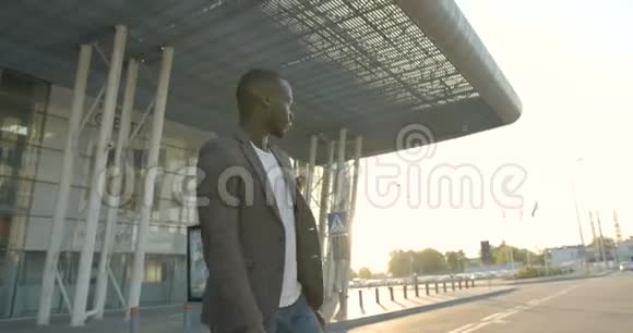 平静迷人的非洲男人穿着休闲服装看着一边在日落时穿过马路4K录像视频的预览图