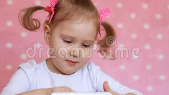 小女孩玩手机宝贝在智能手机上使用游戏应用程序肖像特写视频的预览图