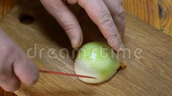 厨师用红刀将洋葱切成小块放在木切割板上视频的预览图