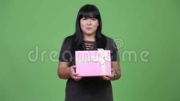 美丽超重的亚洲女人捧着礼品盒微笑视频的预览图