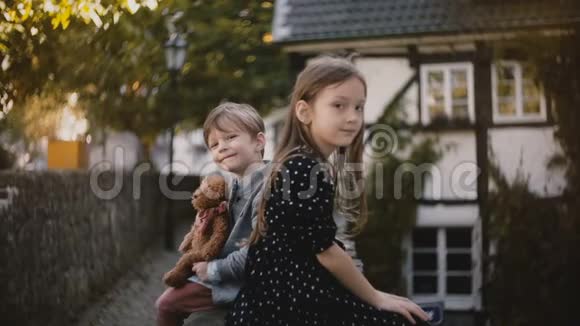 小欧洲男孩和女孩的肖像兄妹俩坐在一起看镜头一半的木屋4K视频的预览图