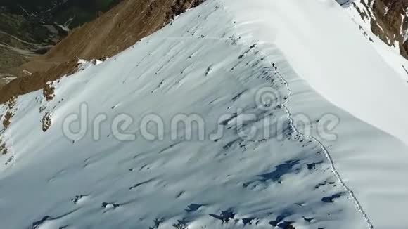 登山者在山上攀登一座雪岭用无人机射击视频的预览图