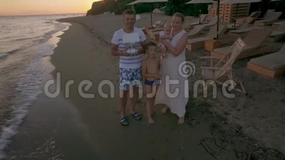 海滩上的家人和沿海城镇的空中场景希腊特里科佛海滩视频的预览图