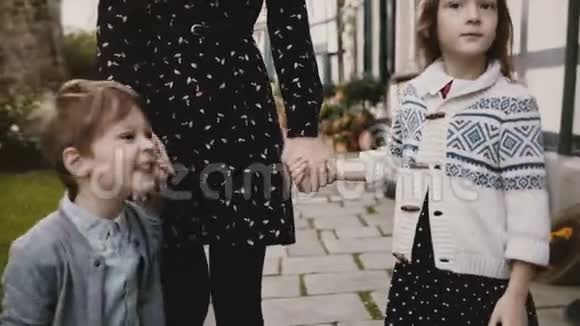 两个欧洲孩子和母亲牵手冷静严肃的男孩和女孩站在妈妈身边生活方式拍摄4K视频的预览图