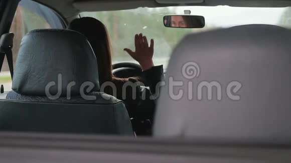 年轻的棕色头发的女人敲着一辆破车的方向盘视频的预览图