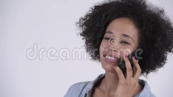 年轻快乐的非洲女人的脸在电话里说话视频的预览图