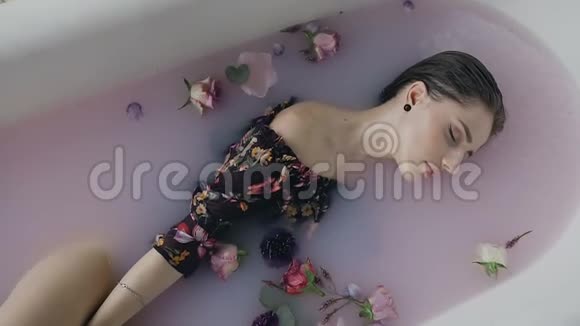 可爱的女孩在温水浴与牛奶和芬芳的花蕾水疗治疗皮肤年轻化有魅力的女人视频的预览图