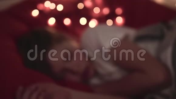 晚上男孩睡在一间昏暗的房间里的软床上视频的预览图