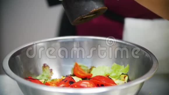 厨师在碗里的蔬菜中加入香料在厨师的手里视频的预览图