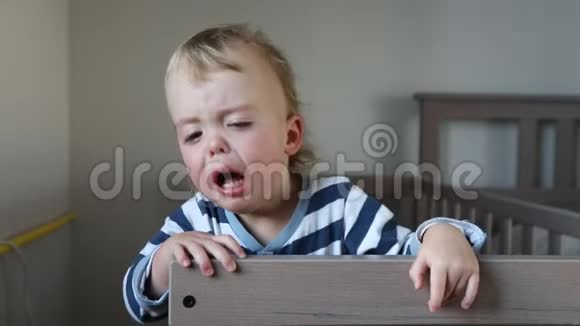 在家的婴儿床上哭泣的男孩视频的预览图
